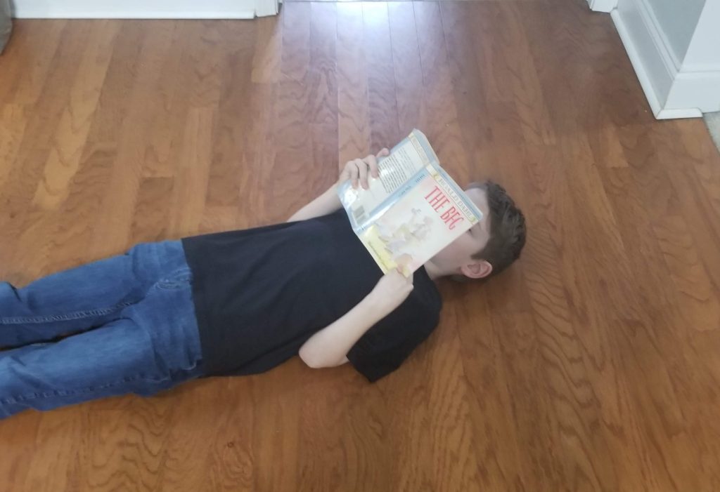 Homeschooling while reading on the kitchen floor